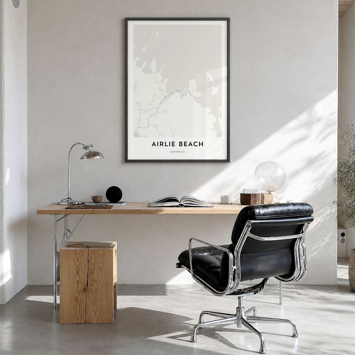 Airlie Beach Map Poster in a black wood frame, hanging in a bright home office