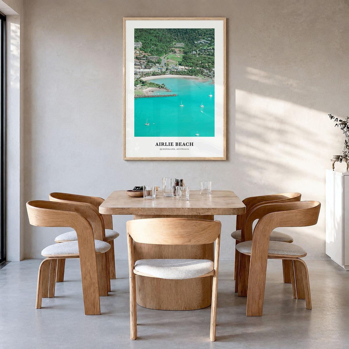 Airlie Beach Classic Poster in a natural wood frame, hanging in a dining room