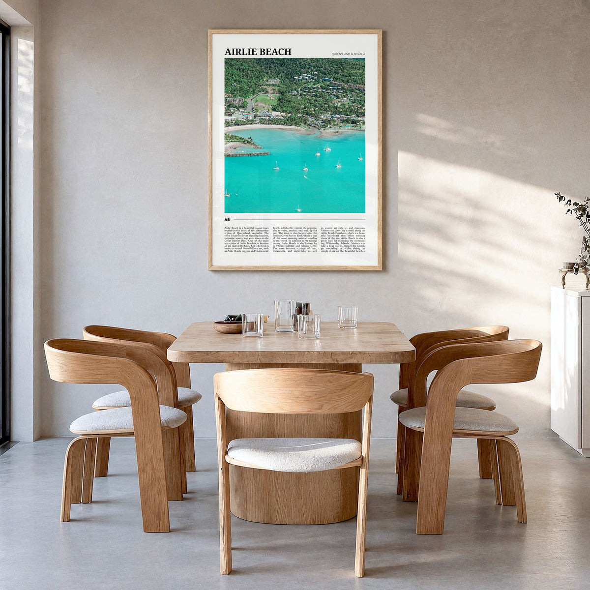 Airlie Beach Travel Poster in a natural wood frame, hanging in a dining room