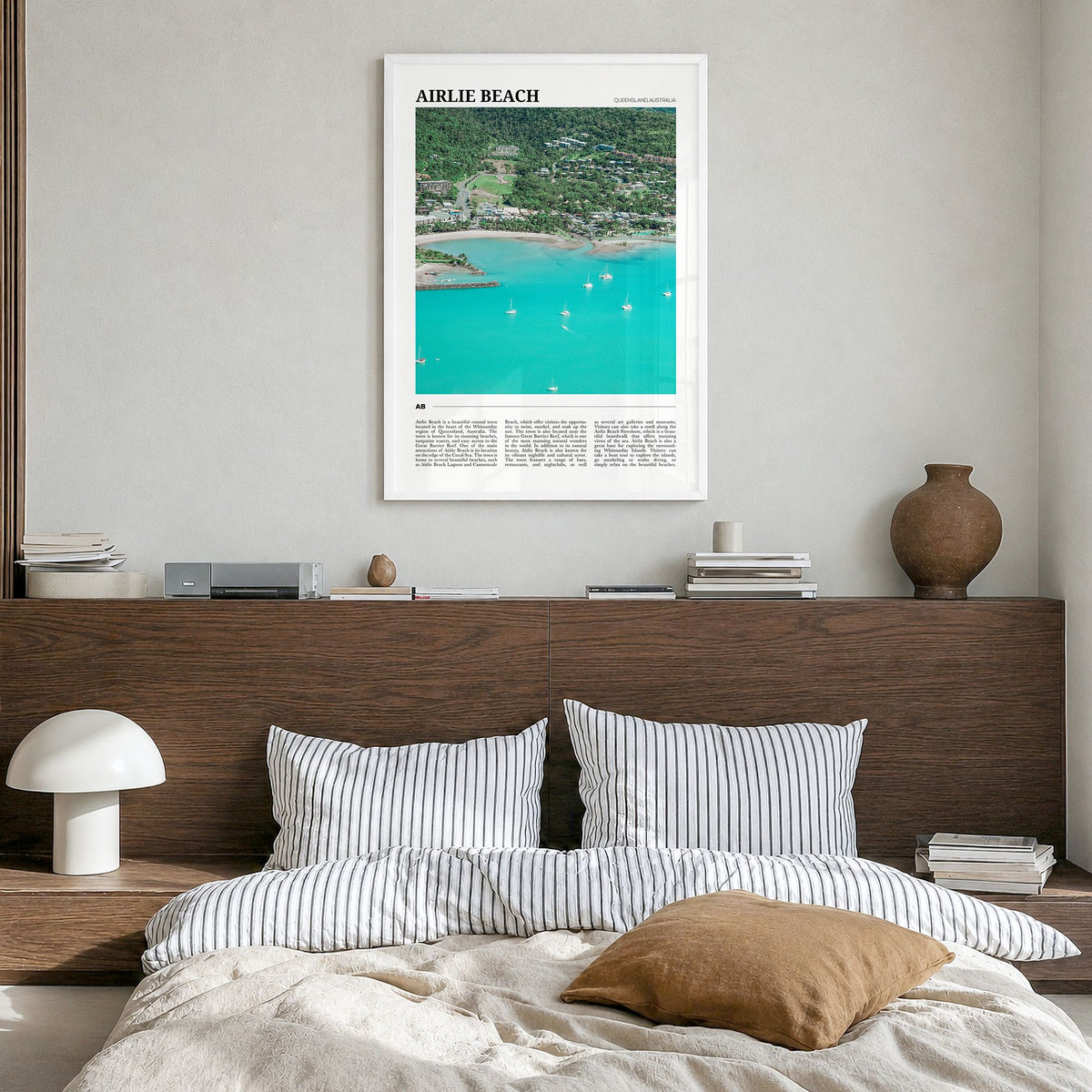 Airlie Beach Travel Poster in a white wood frame, hanging in a bedroom