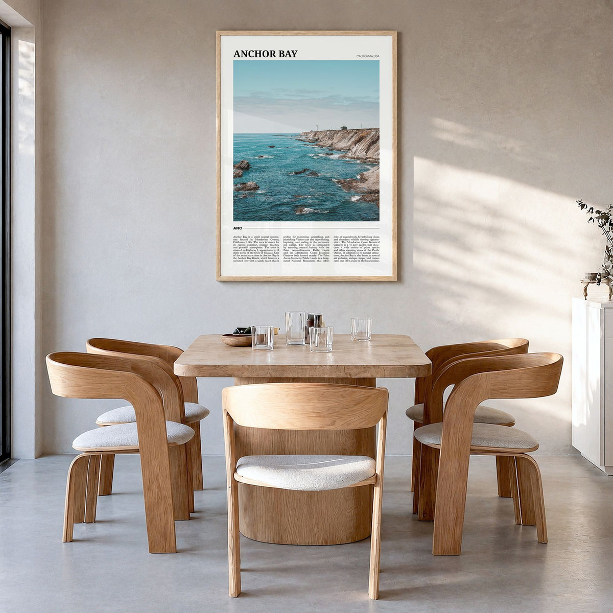 Anchor Bay Travel Poster in a natural wood frame, hanging in a dining room