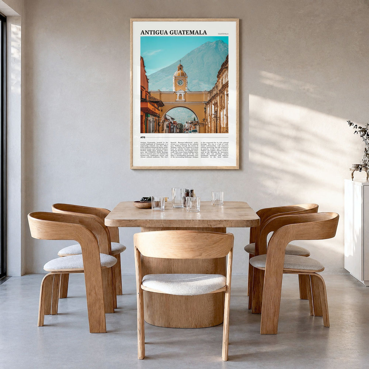 Antigua Guatemala Travel Poster in a natural wood frame, hanging in a dining room