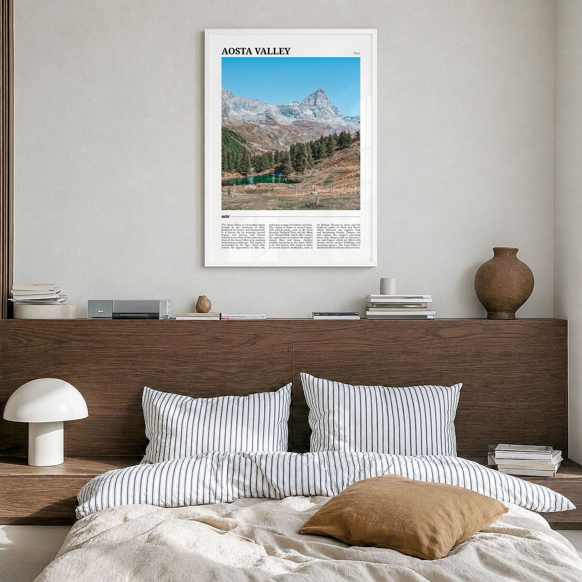Aosta Valley Travel Poster in a white wood frame, hanging in a bedroom