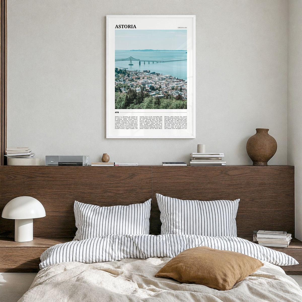 Astoria, Oregon Travel Poster in a white wood frame, hanging in a bedroom