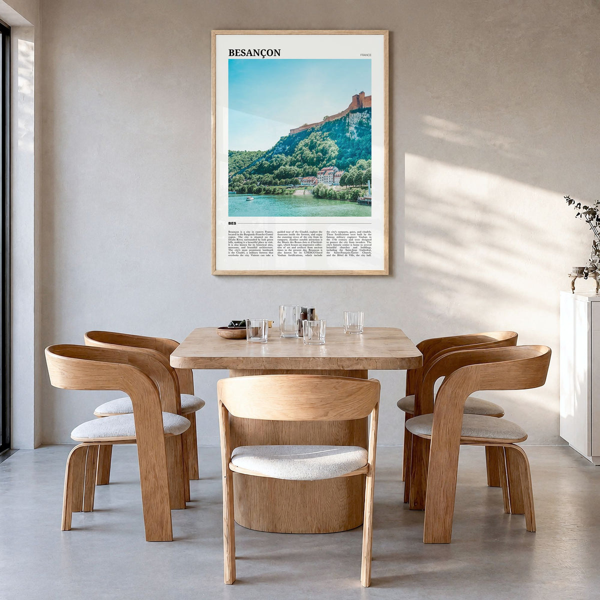 Besançon Travel Poster in a natural wood frame, hanging in a dining room