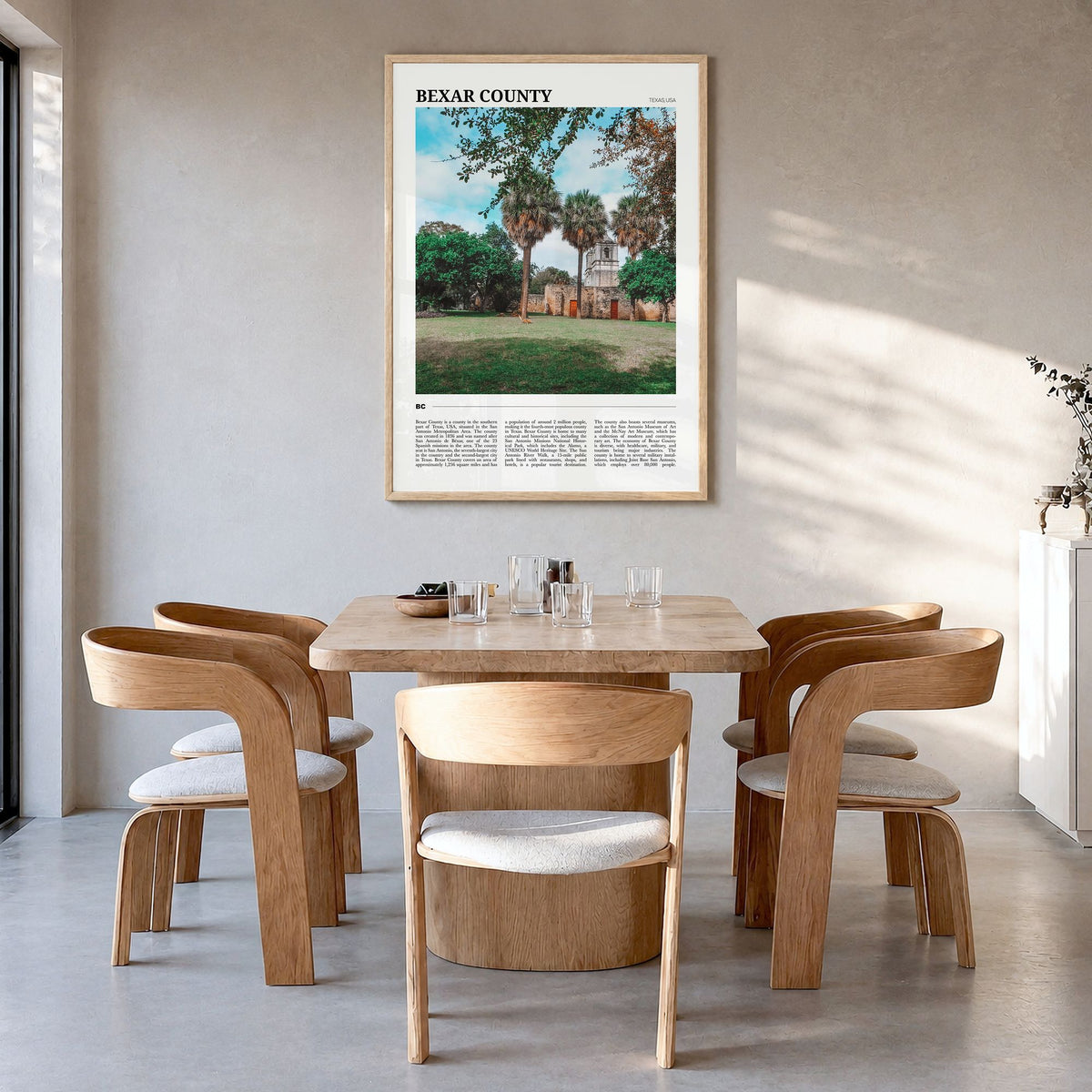 Bexar County Travel Poster in a natural wood frame, hanging in a dining room