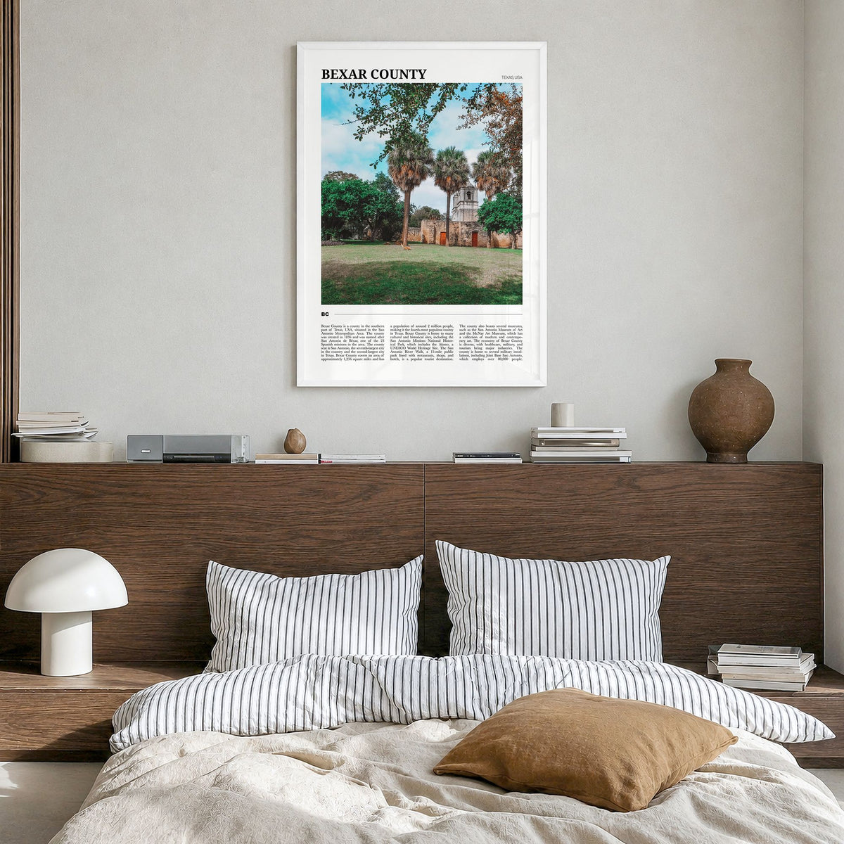 Bexar County Travel Poster in a white wood frame, hanging in a bedroom