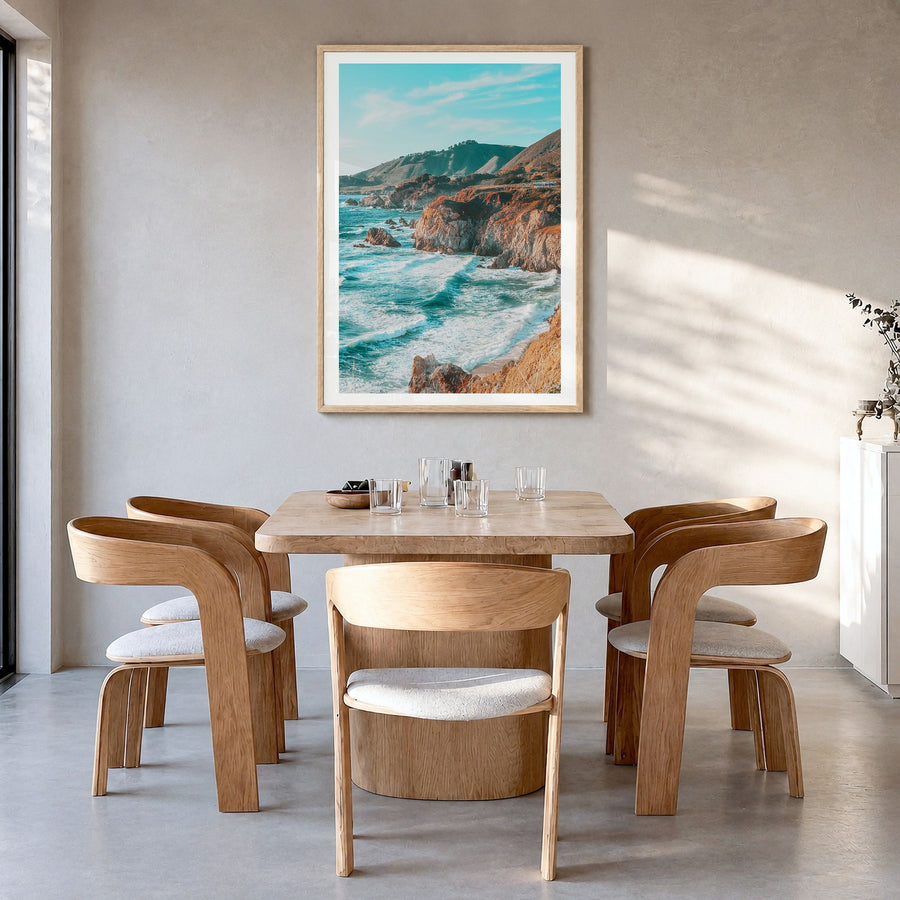 Big Sur Photo No 1 Poster in a natural wood frame, hanging in a dining room, white border