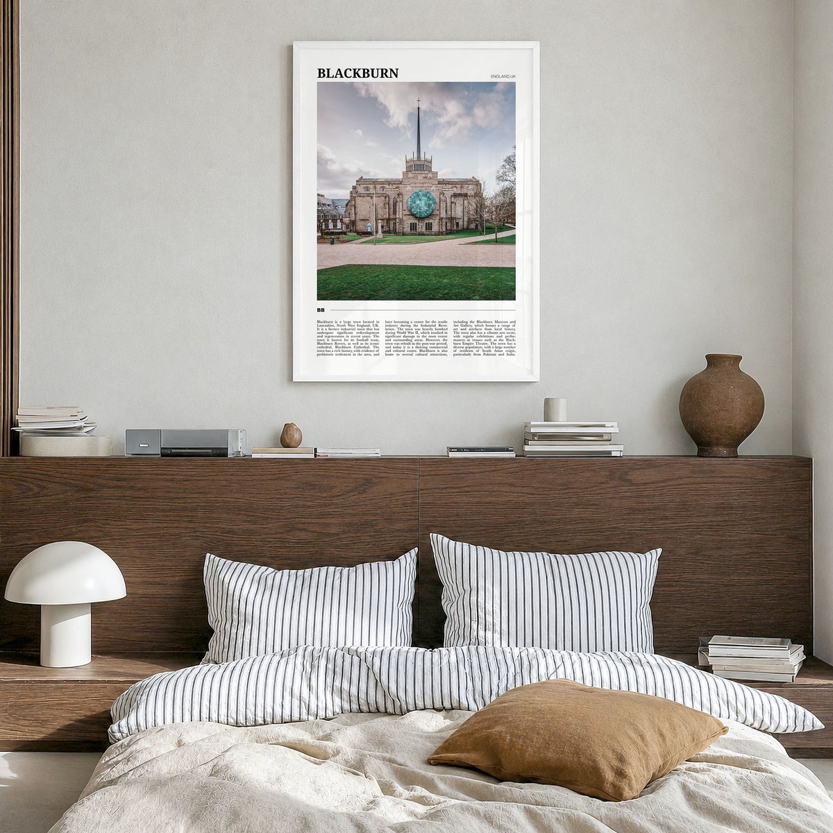 Blackburn Travel Poster in a white wood frame, hanging in a bedroom