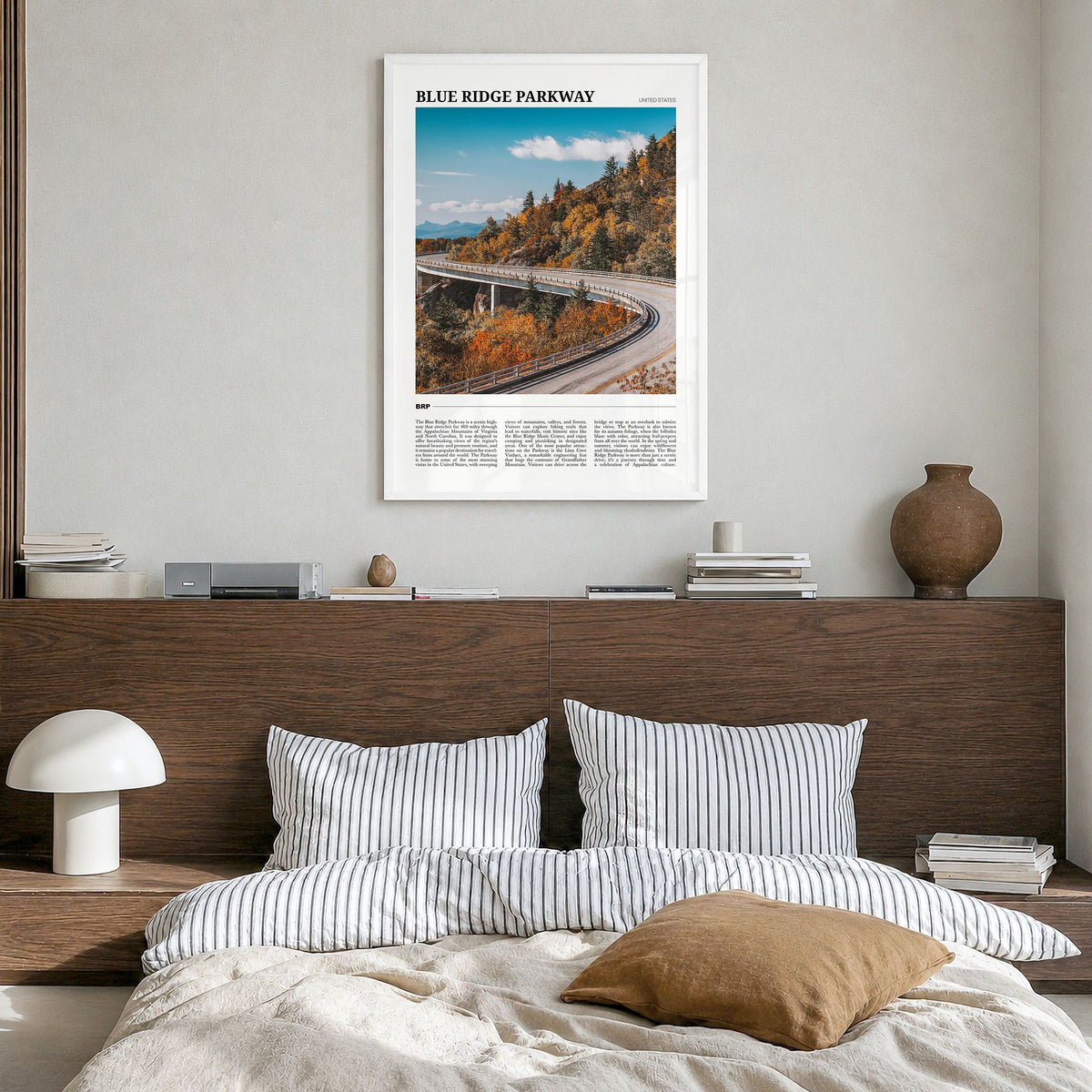 Blue Ridge Parkway Travel Poster in a white wood frame, hanging in a bedroom
