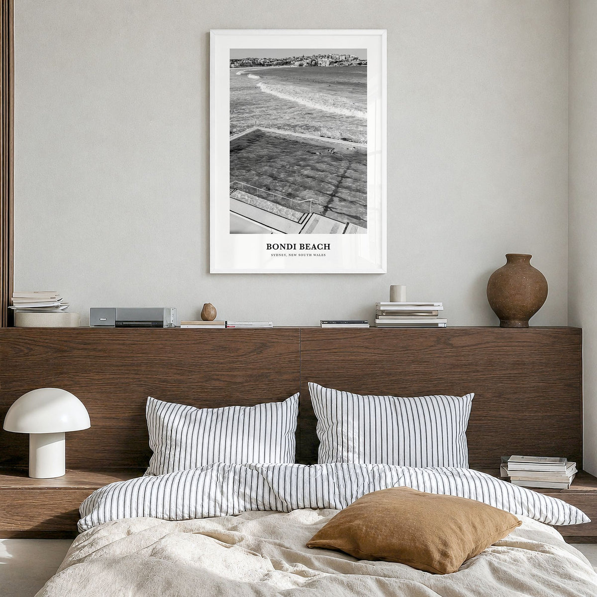 Bondi Beach Classic No 1 Poster in a white wood frame, hanging in a bedroom
