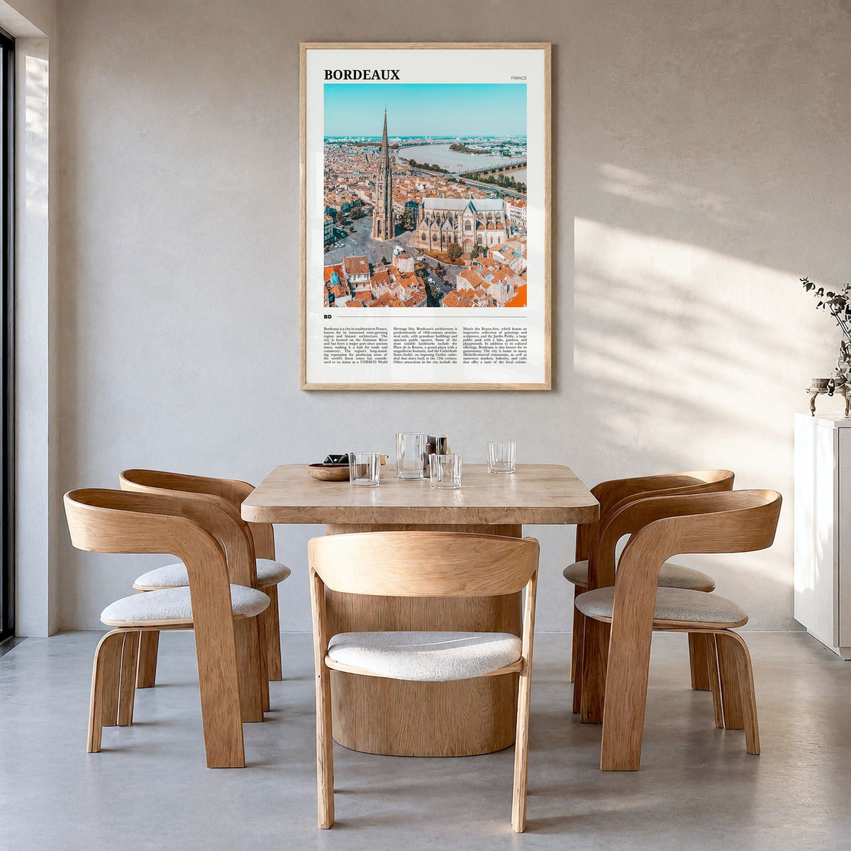 Bordeaux Travel Poster in a natural wood frame, hanging in a dining room