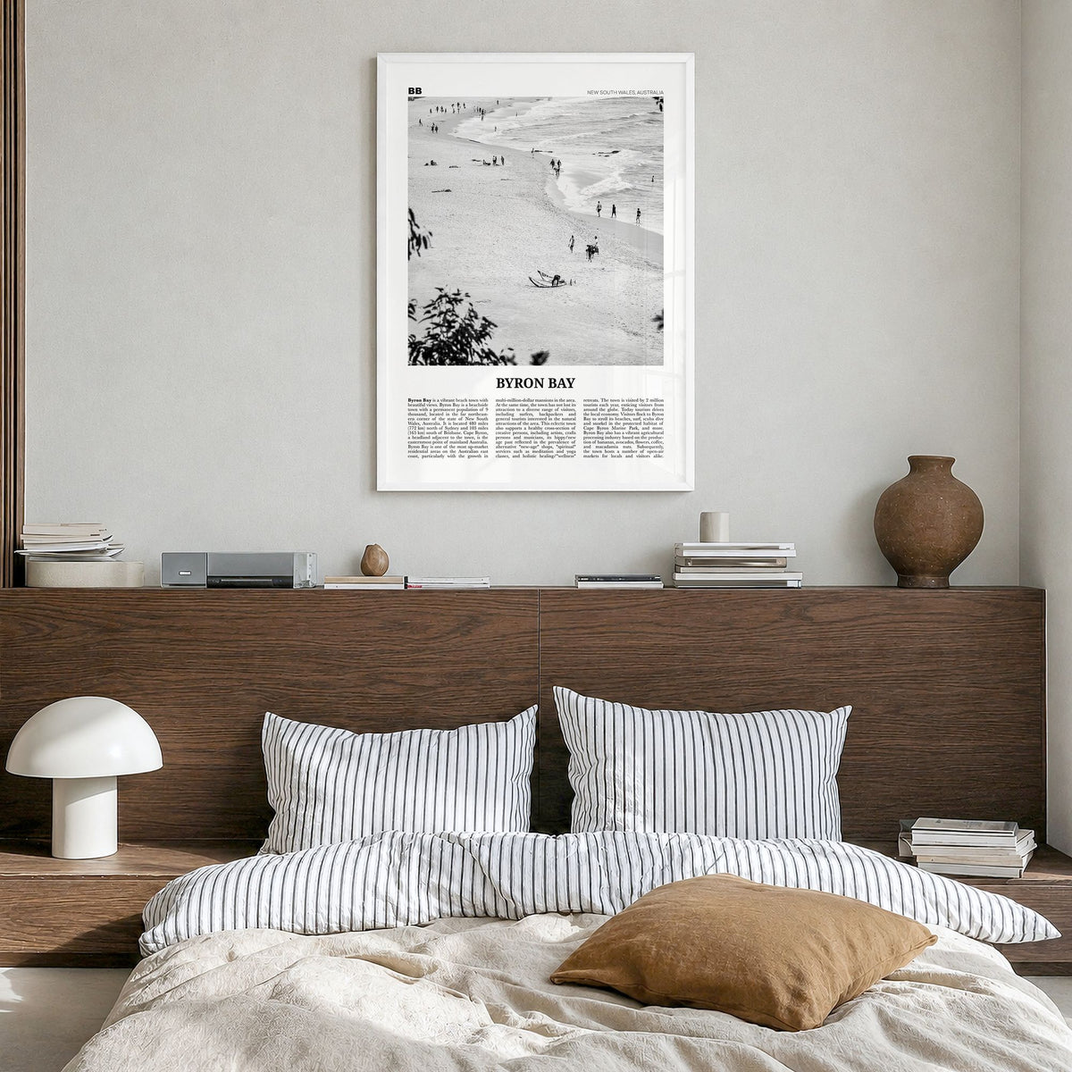 Byron Bay Newspaper No 1 Poster in a white wood frame, hanging in a bedroom