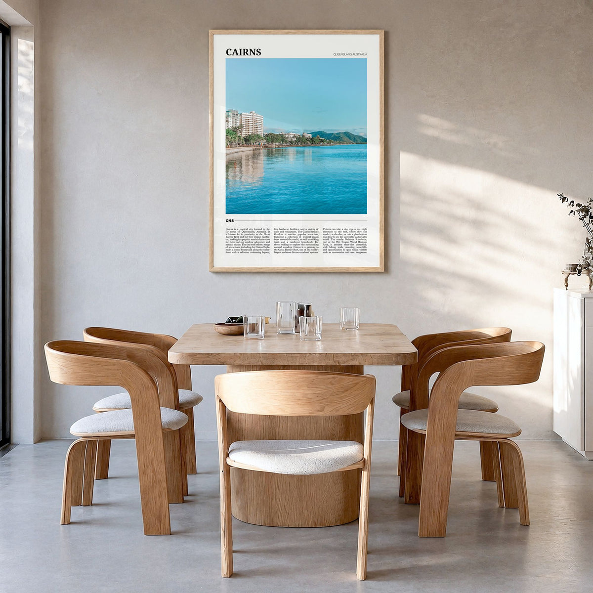 Cairns Travel Poster in a natural wood frame, hanging in a dining room