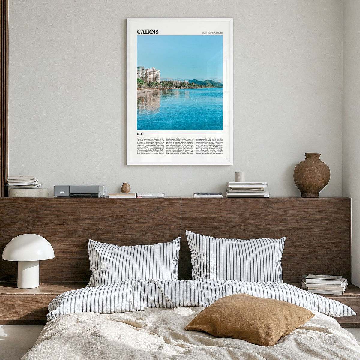 Cairns Travel Poster in a white wood frame, hanging in a bedroom