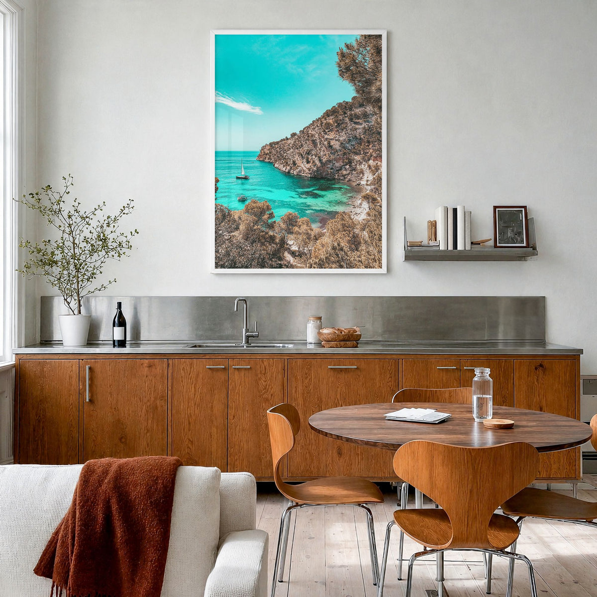 Cala Blanca Photo Poster in a white wood frame, hanging in a kitchen with a dining area, full image (no border)
