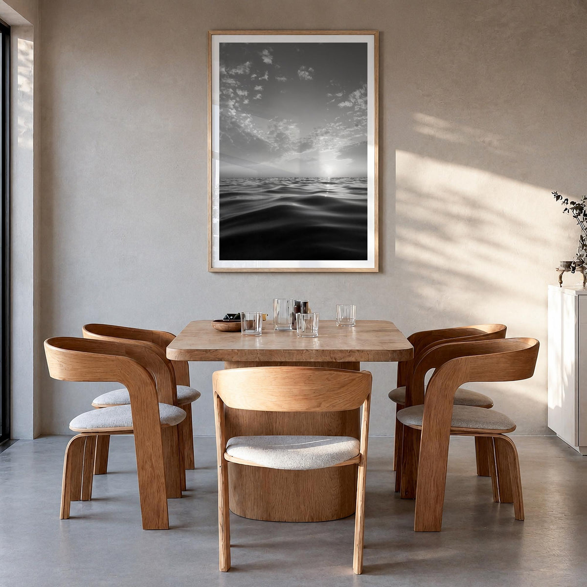 Calm Sunset black & white photo poster – vertical wall art in natural wood frame with white border, hanging on wall