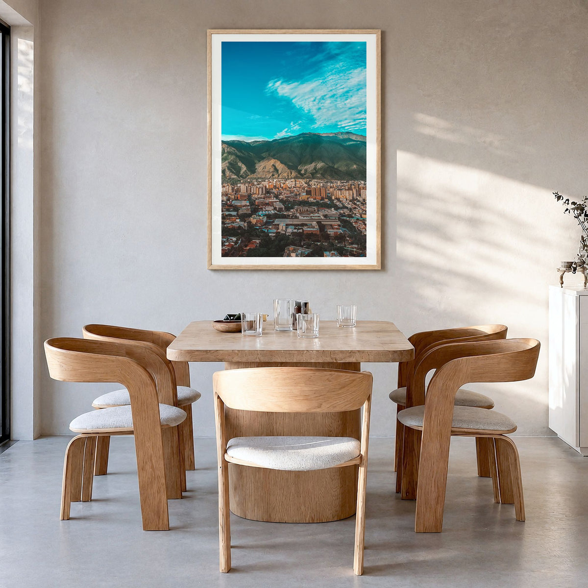 Caracas Photo Poster in a natural wood frame, hanging in a dining room, white border
