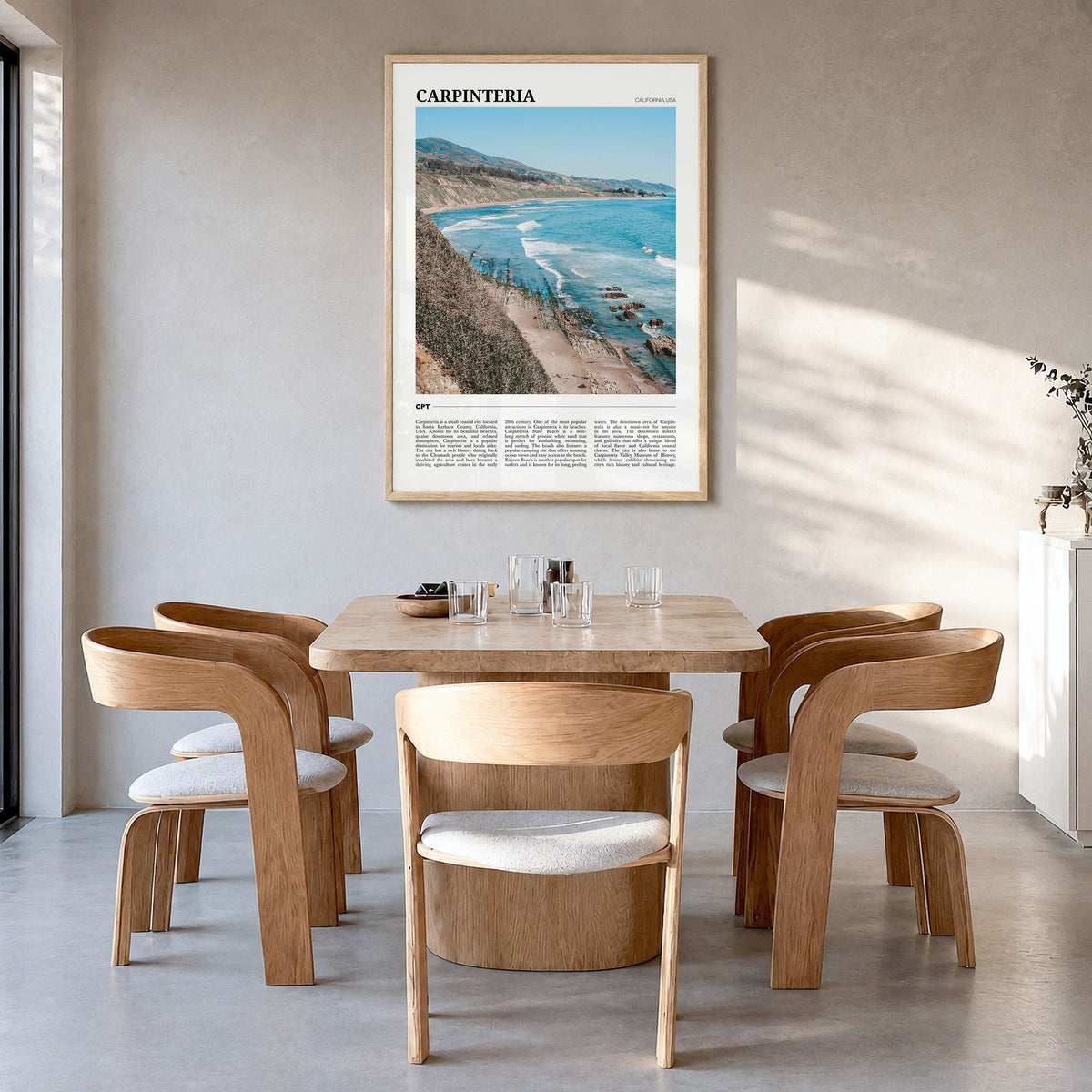 Carpinteria Travel Poster in a natural wood frame, hanging in a dining room