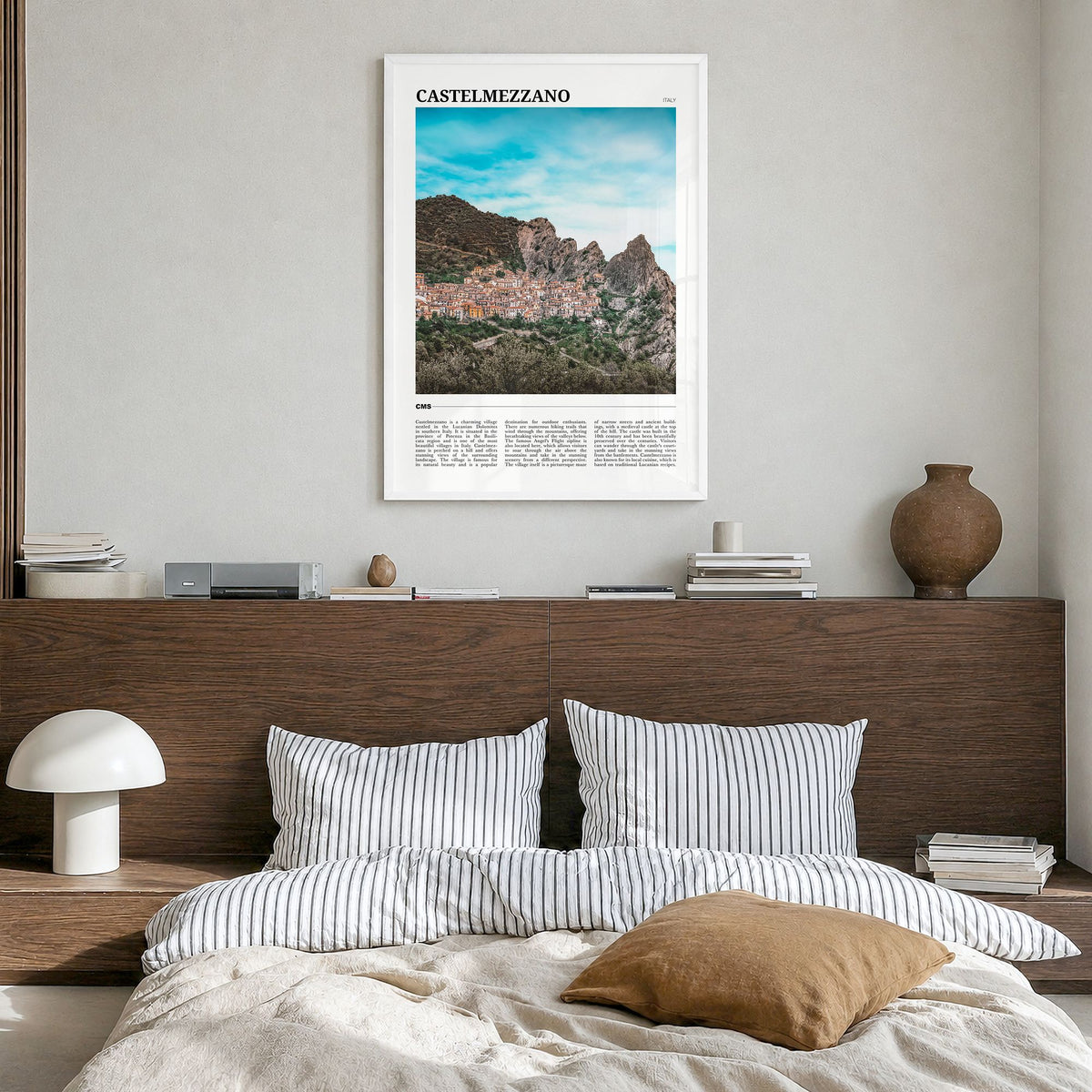 Castelmezzano Travel Poster in a white wood frame, hanging in a bedroom