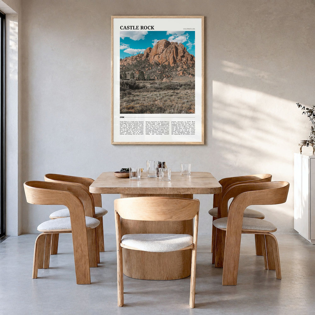 Castle Rock Travel Poster in a natural wood frame, hanging in a dining room