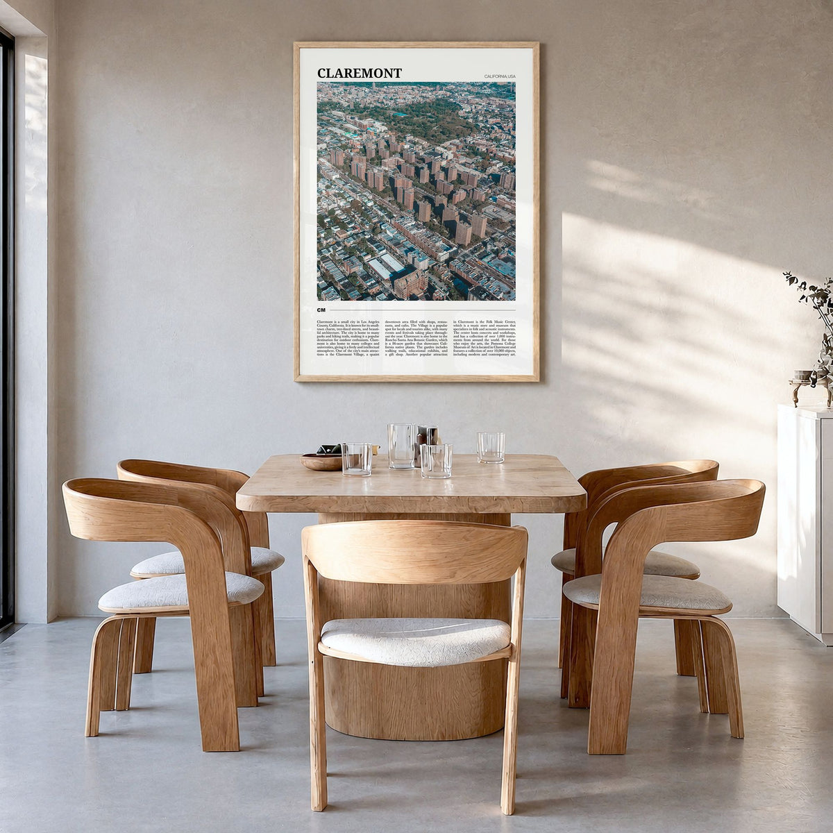 Claremont Travel Poster in a natural wood frame, hanging in a dining room