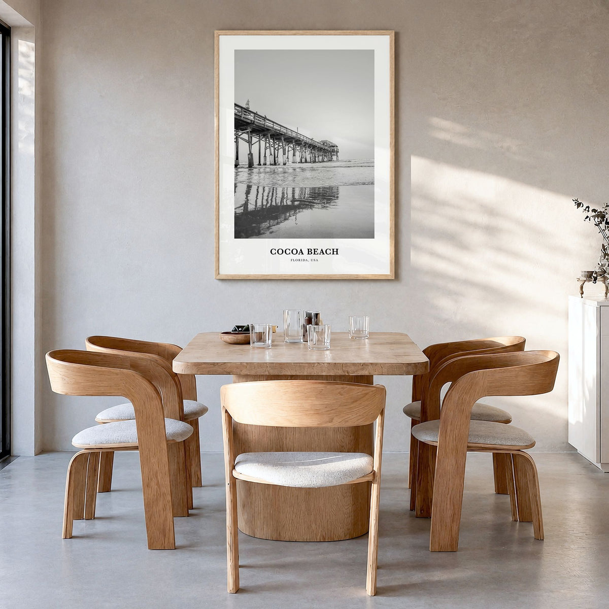 Cocoa Beach Classic Poster in a natural wood frame, hanging in a dining room