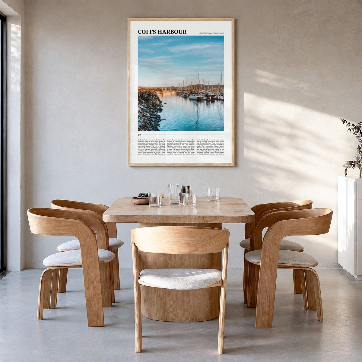 Coffs Harbour Travel Poster in a natural wood frame, hanging in a dining room