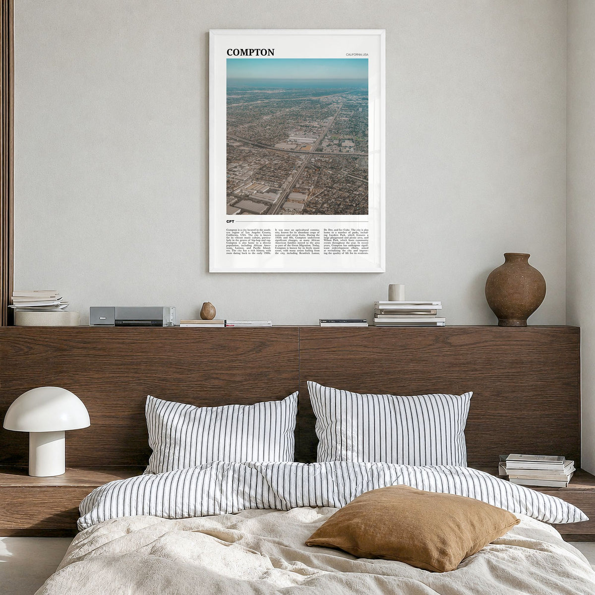 Compton Travel Poster in a white wood frame, hanging in a bedroom