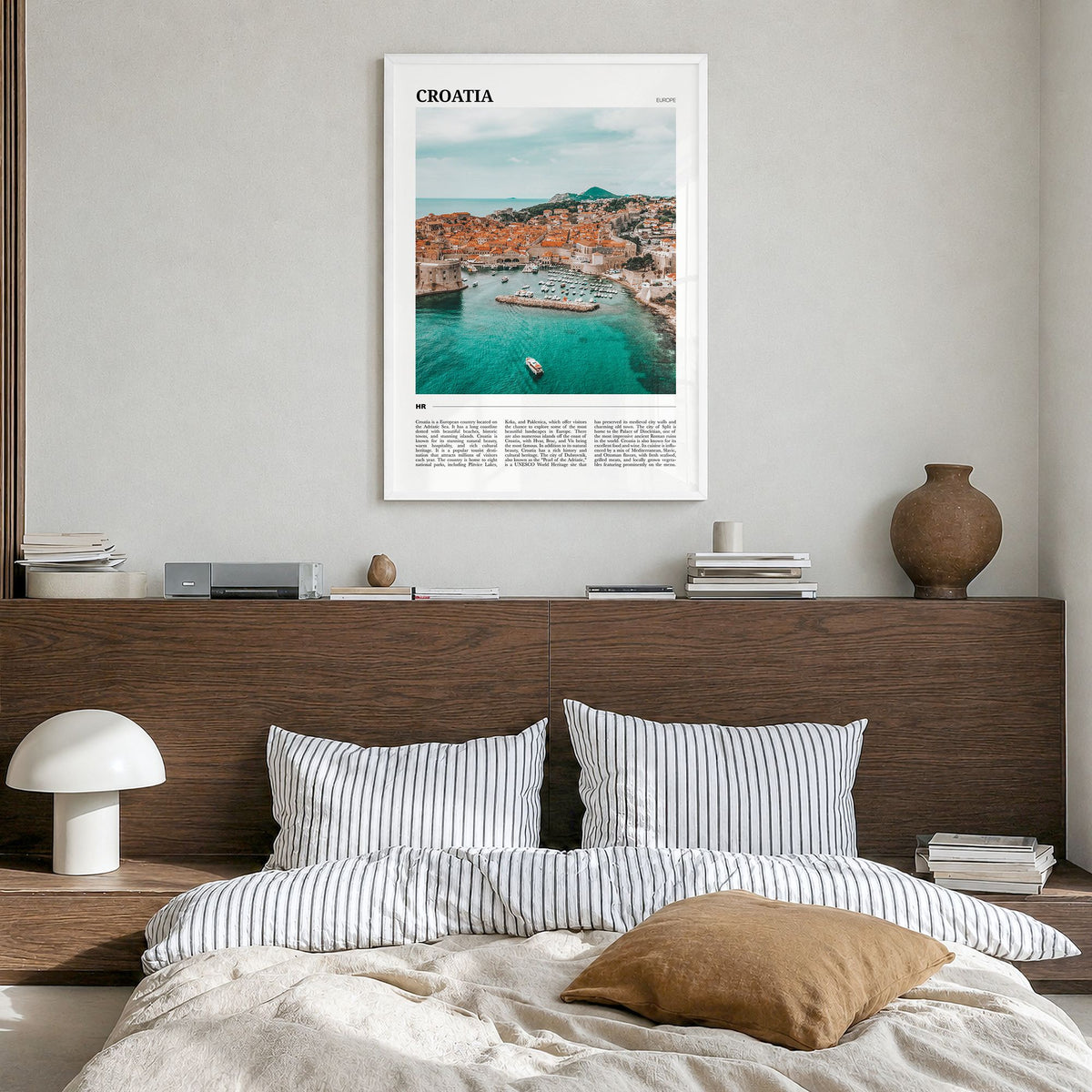 Croatia Travel Poster in a white wood frame, hanging in a bedroom