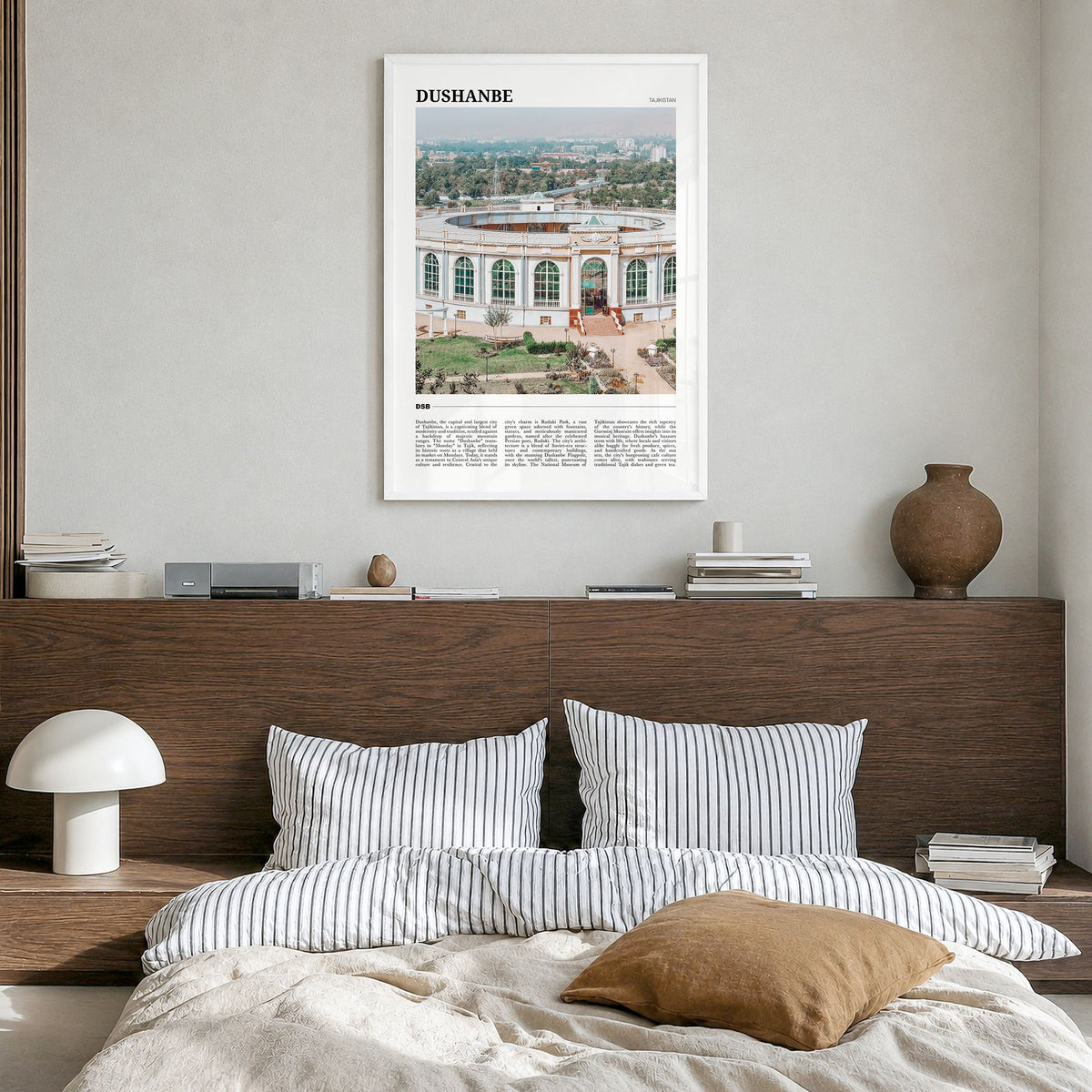 Dushanbe Travel Poster in a white wood frame, hanging in a bedroom
