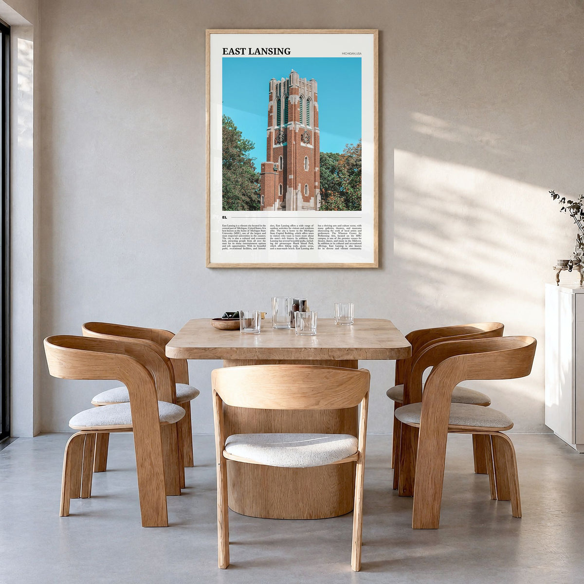 East Lansing Travel Poster in a natural wood frame, hanging in a dining room