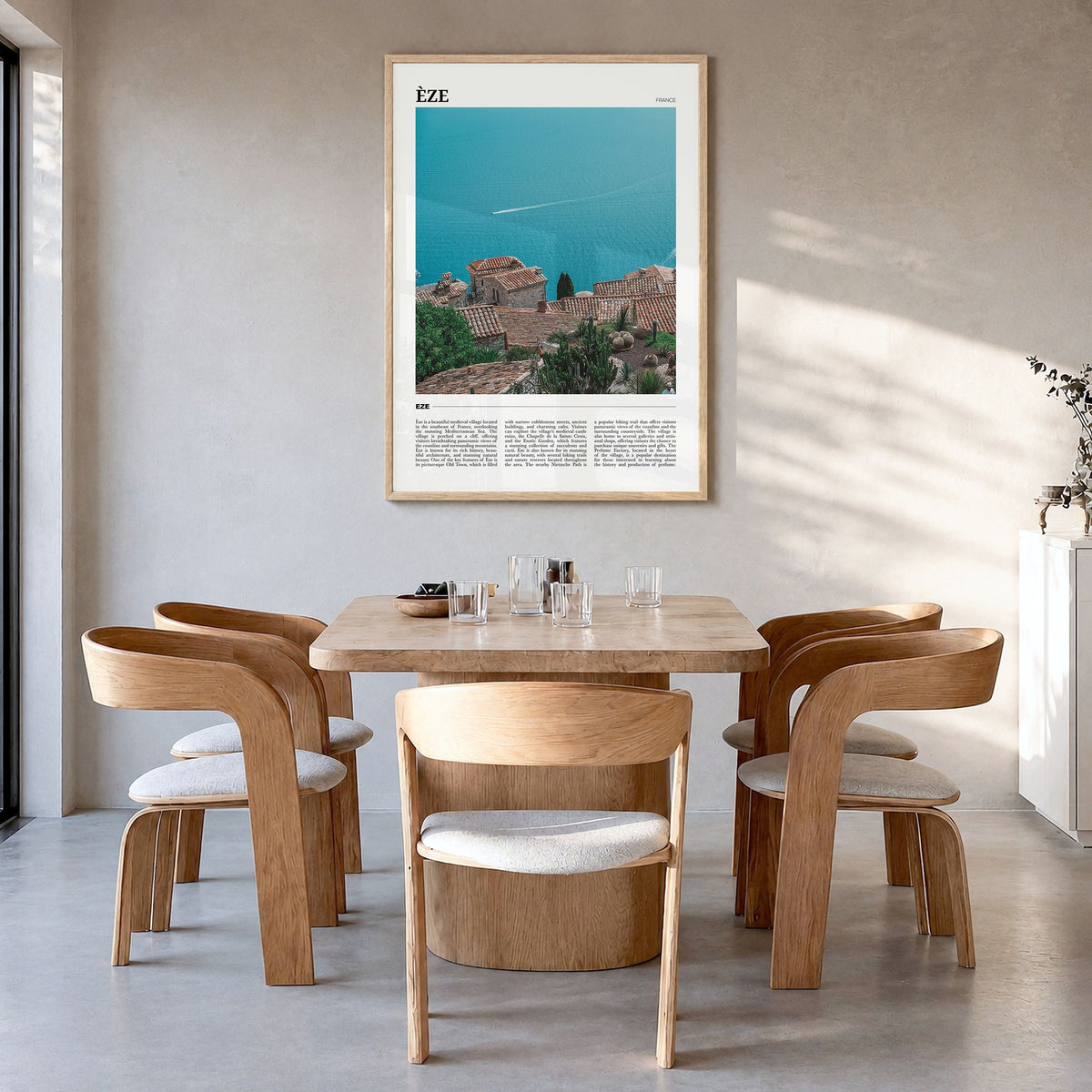 Èze Travel Poster in a natural wood frame, hanging in a dining room