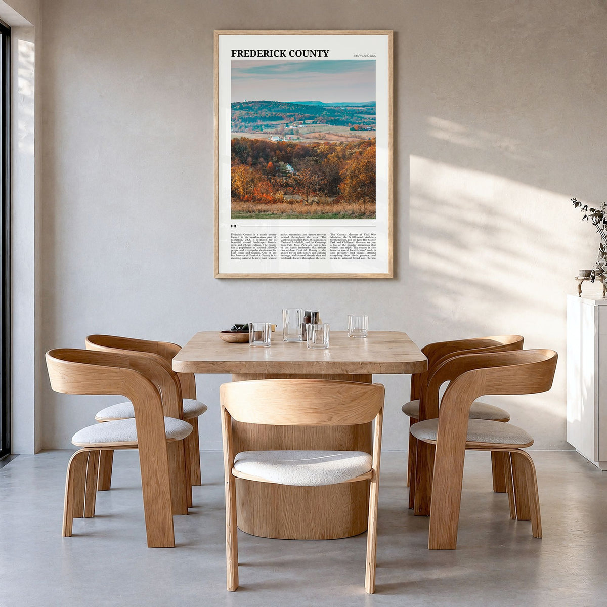 Frederick County Travel Poster in a natural wood frame, hanging in a dining room