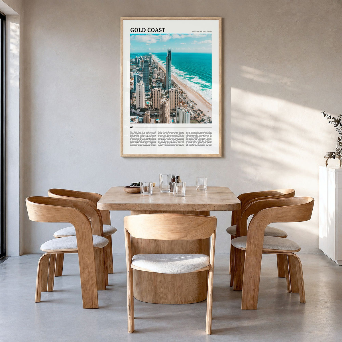 Gold Coast Travel Poster in a natural wood frame, hanging in a dining room