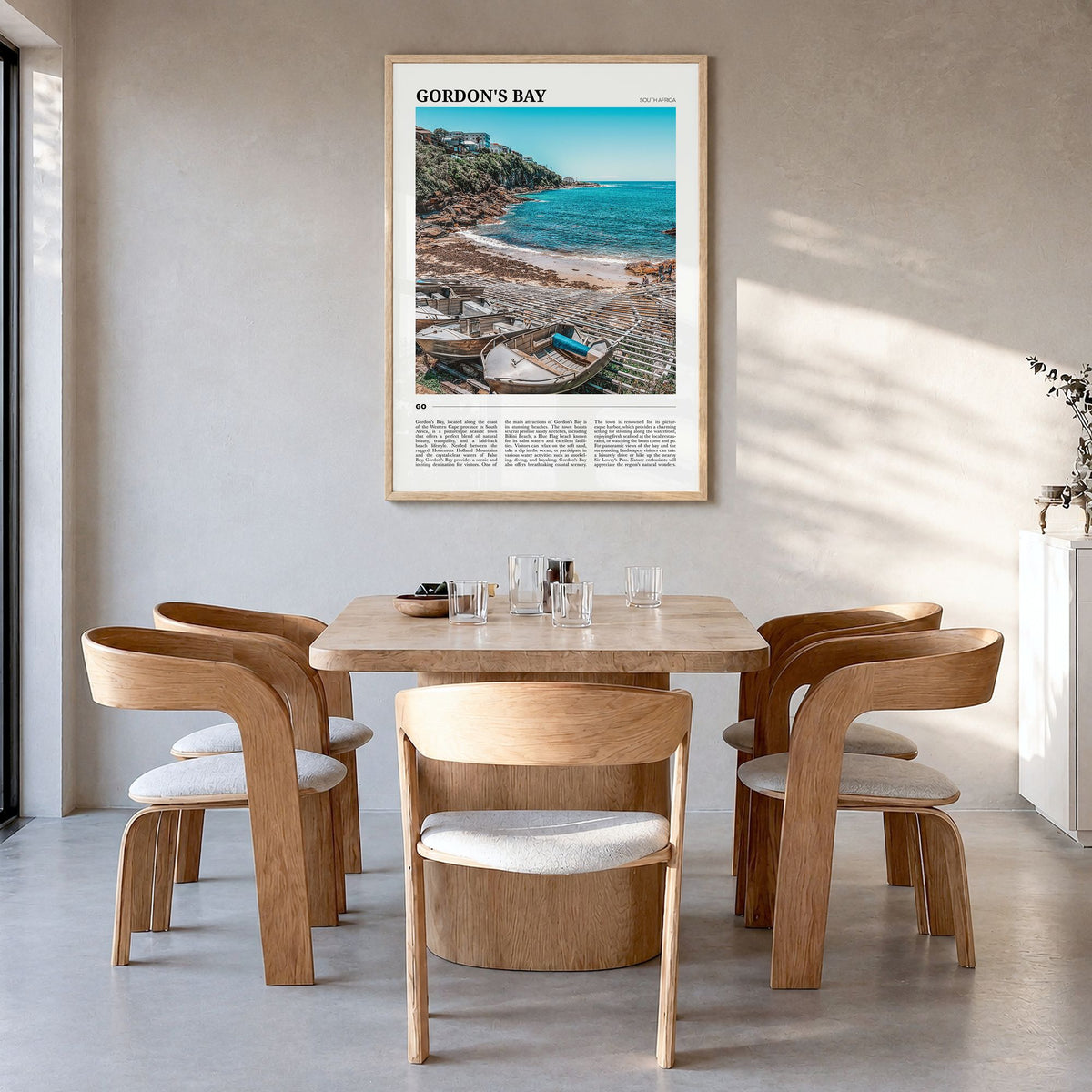 Gordon's Bay Travel Poster in a natural wood frame, hanging in a dining room