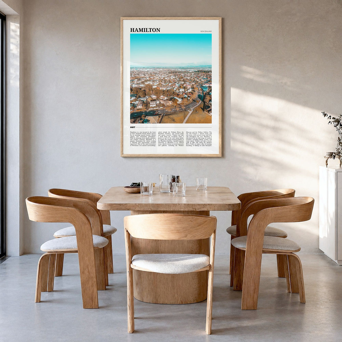 Hamilton, New Zealand Travel Poster in a natural wood frame, hanging in a dining room