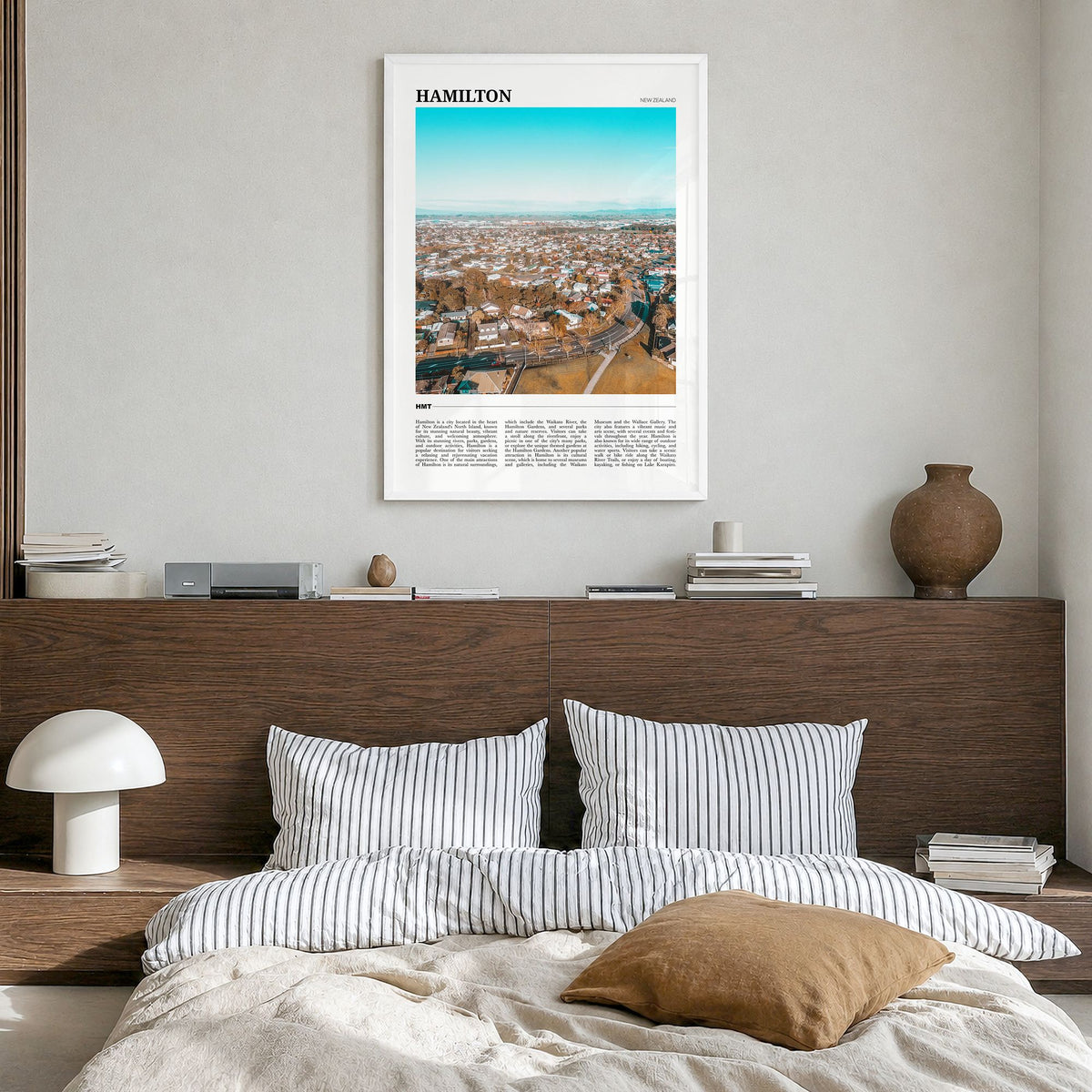 Hamilton, New Zealand Travel Poster in a white wood frame, hanging in a bedroom