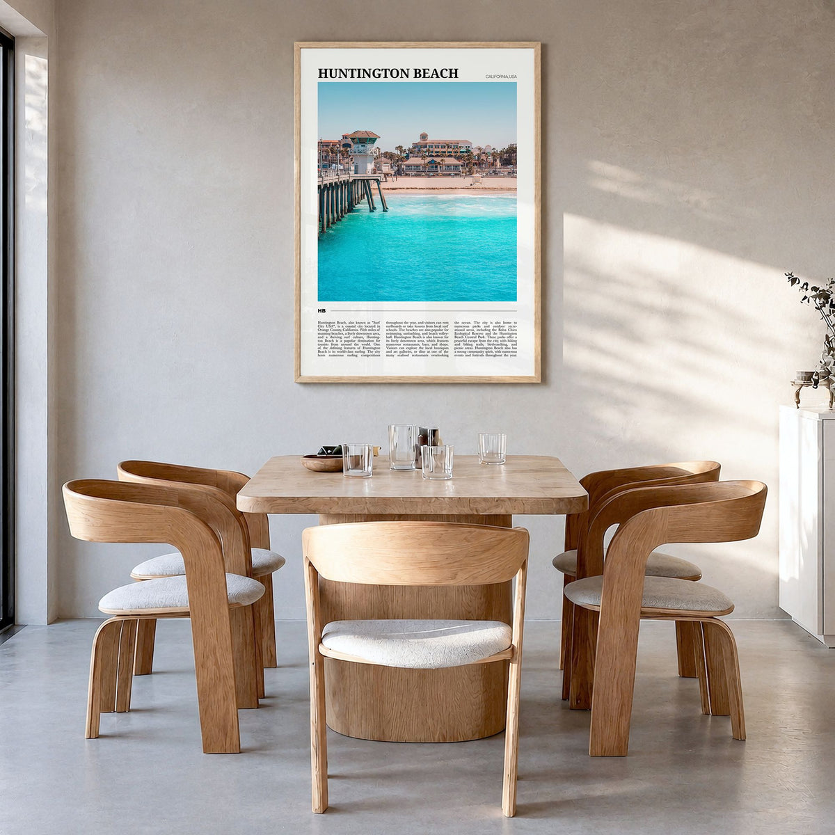 Huntington Beach Travel Poster in a natural wood frame, hanging in a dining room