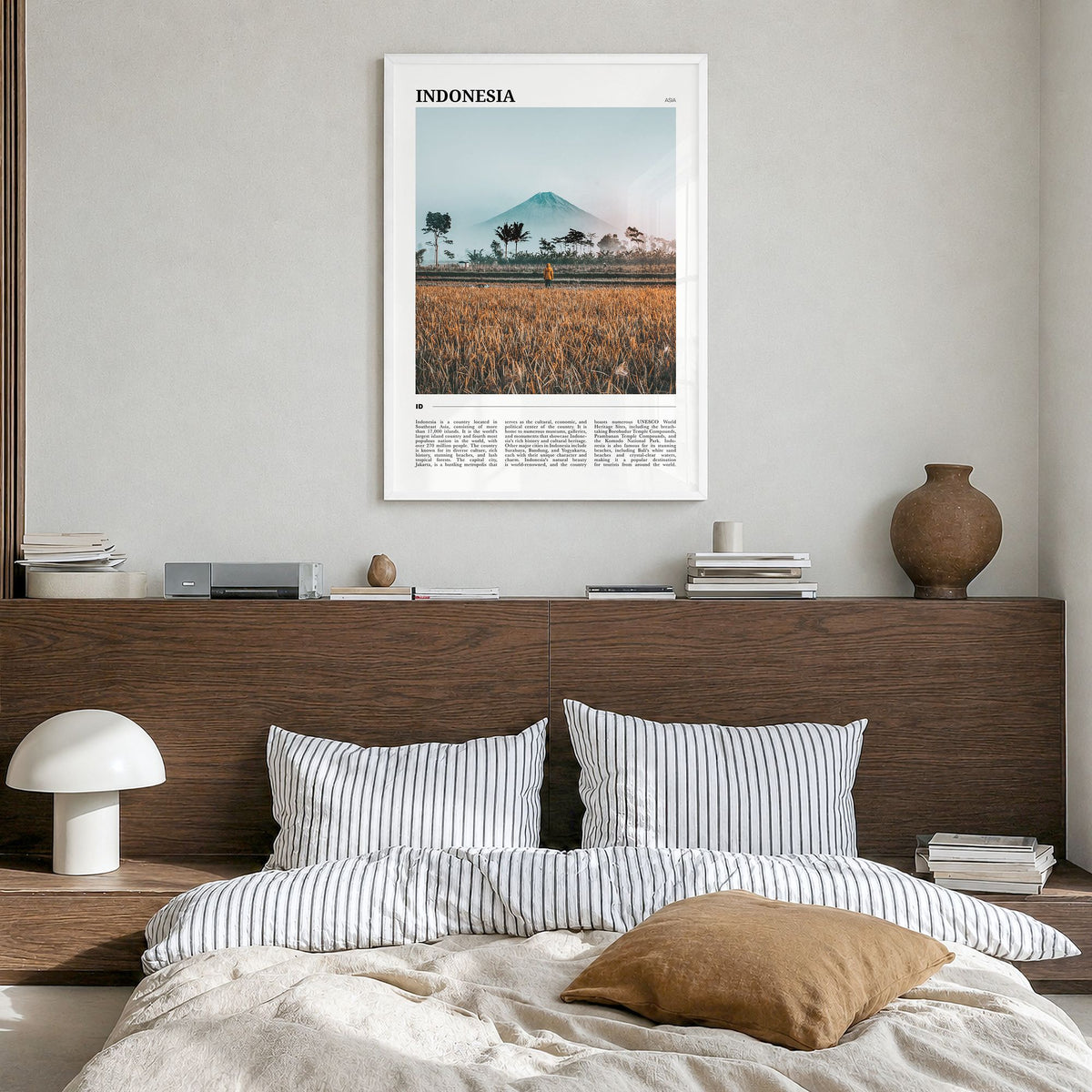 Indonesia Travel Poster in a white wood frame, hanging in a bedroom