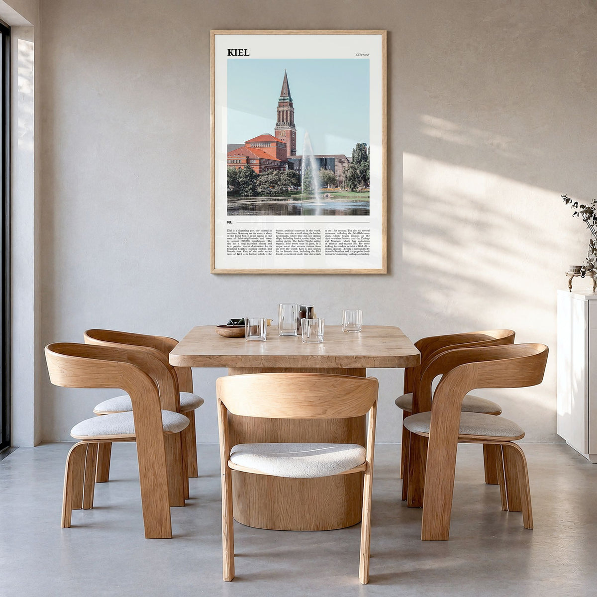 Kiel Travel Poster in a natural wood frame, hanging in a dining room