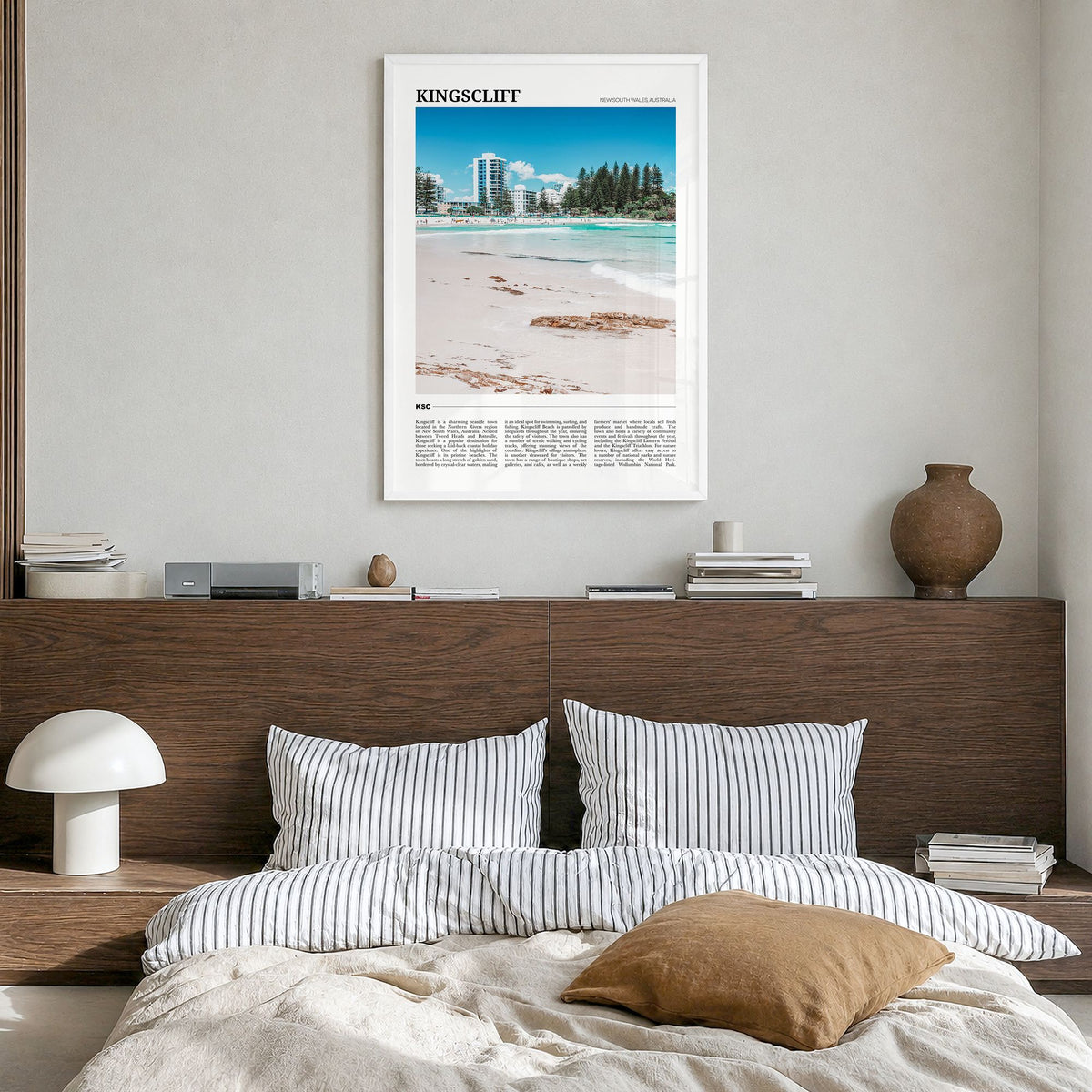 Kingscliff Travel Poster in a white wood frame, hanging in a bedroom