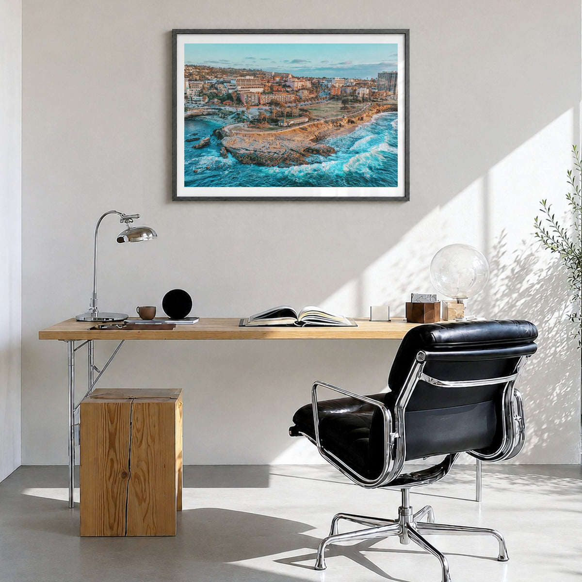 La Jolla Photo Poster in a black wood frame, hanging in a bright home office, white border
