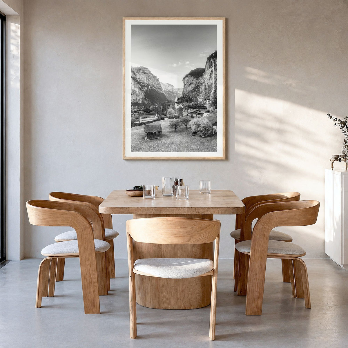 Lauterbrunnen Photo Poster in a natural wood frame, hanging in a dining room, white border