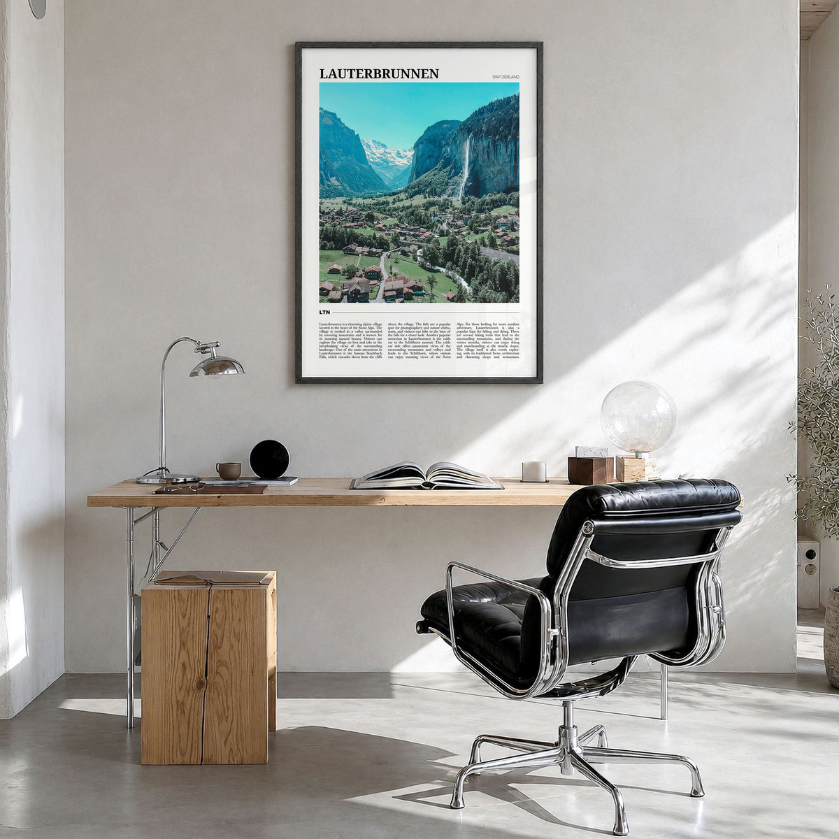 Lauterbrunnen Travel Poster in a black wood frame, hanging in a bright home office