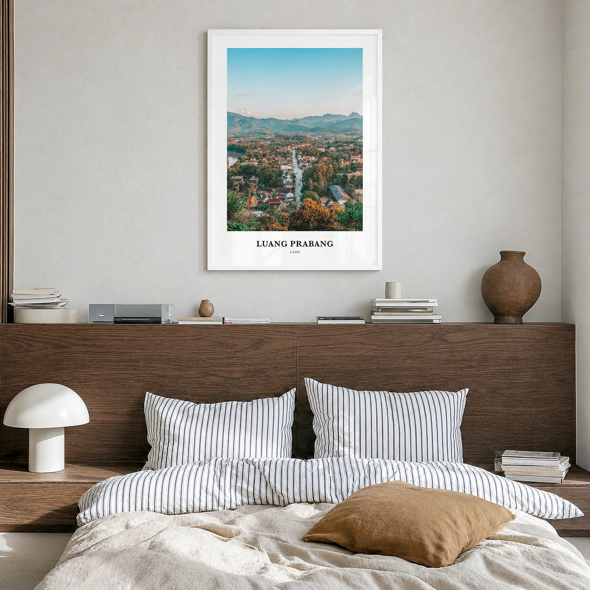 Luang Prabang Classic Poster in a white wood frame, hanging in a bedroom