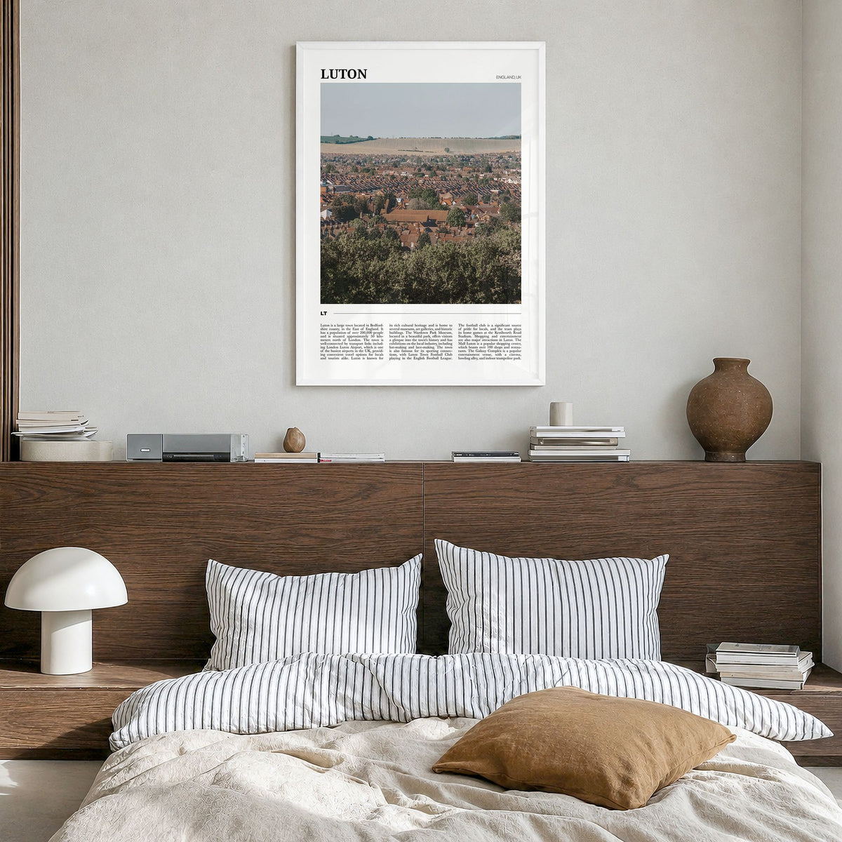 Luton Travel Poster in a white wood frame, hanging in a bedroom