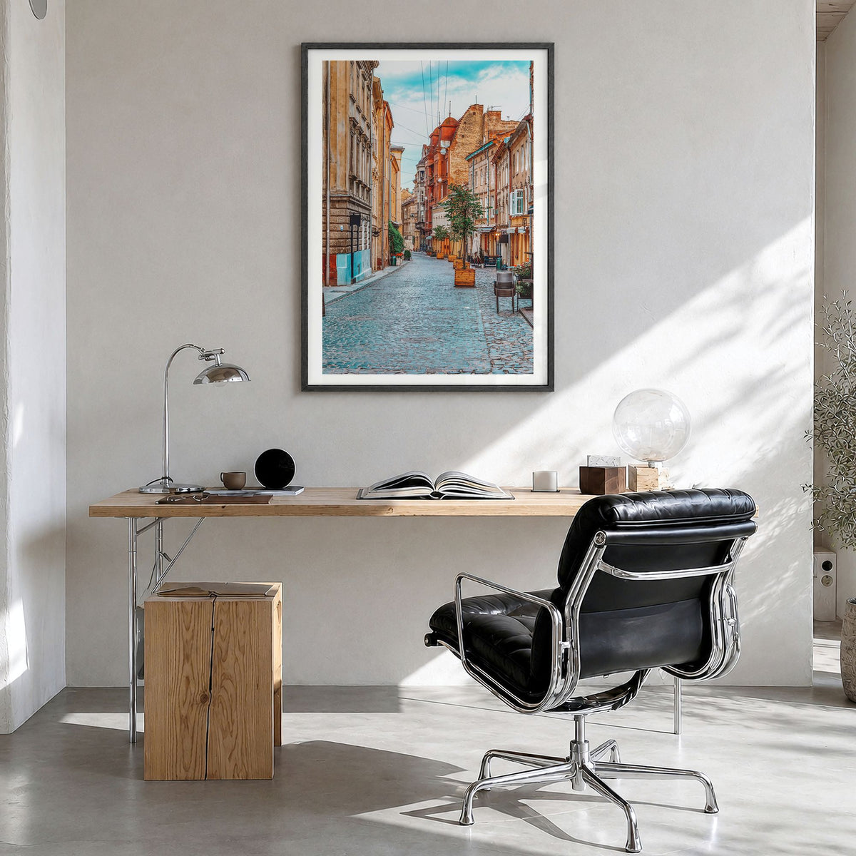 Lviv Photo Poster in a black wood frame, hanging in a bright home office, white border