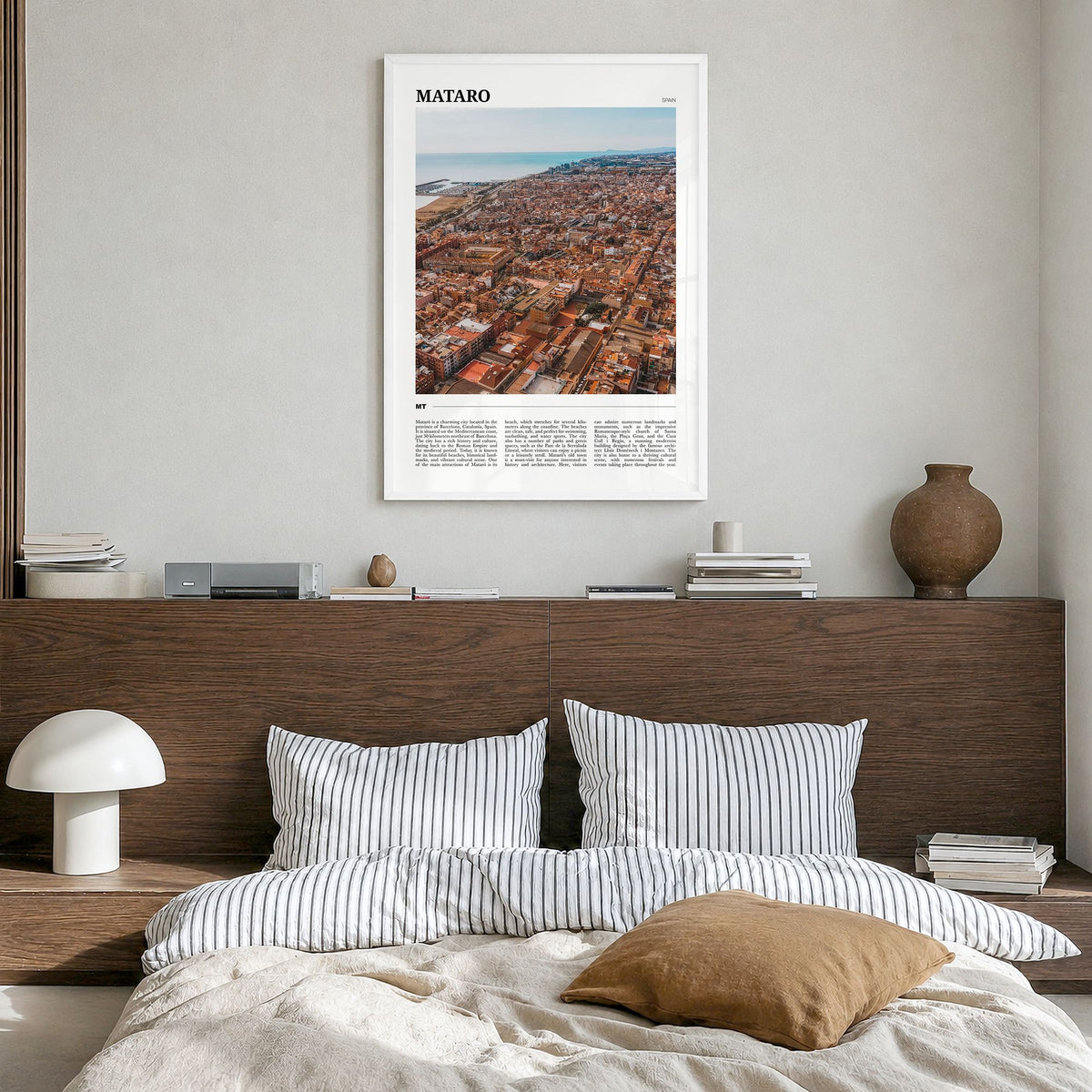 Mataró Travel Poster in a white wood frame, hanging in a bedroom