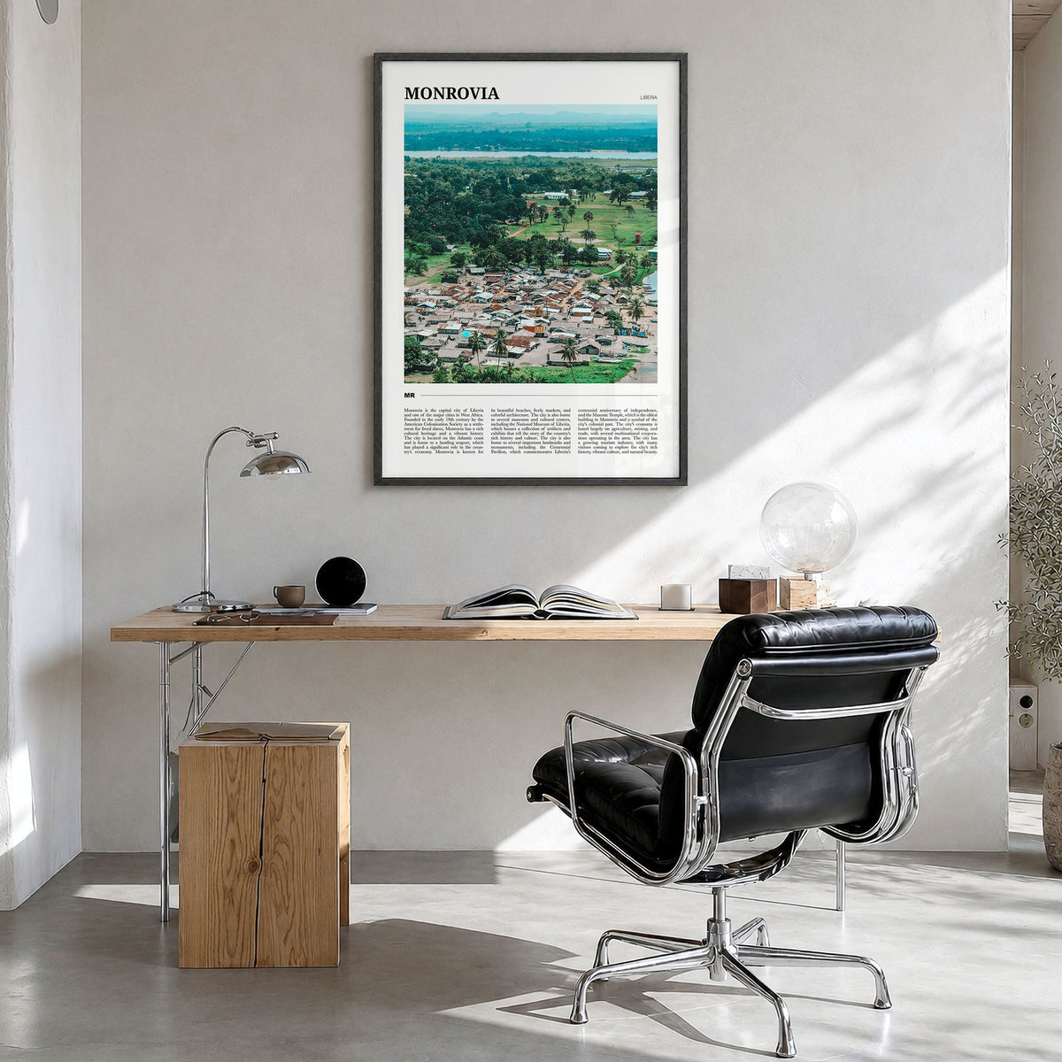 Monrovia Travel No 2 Poster in a black wood frame, hanging in a bright home office